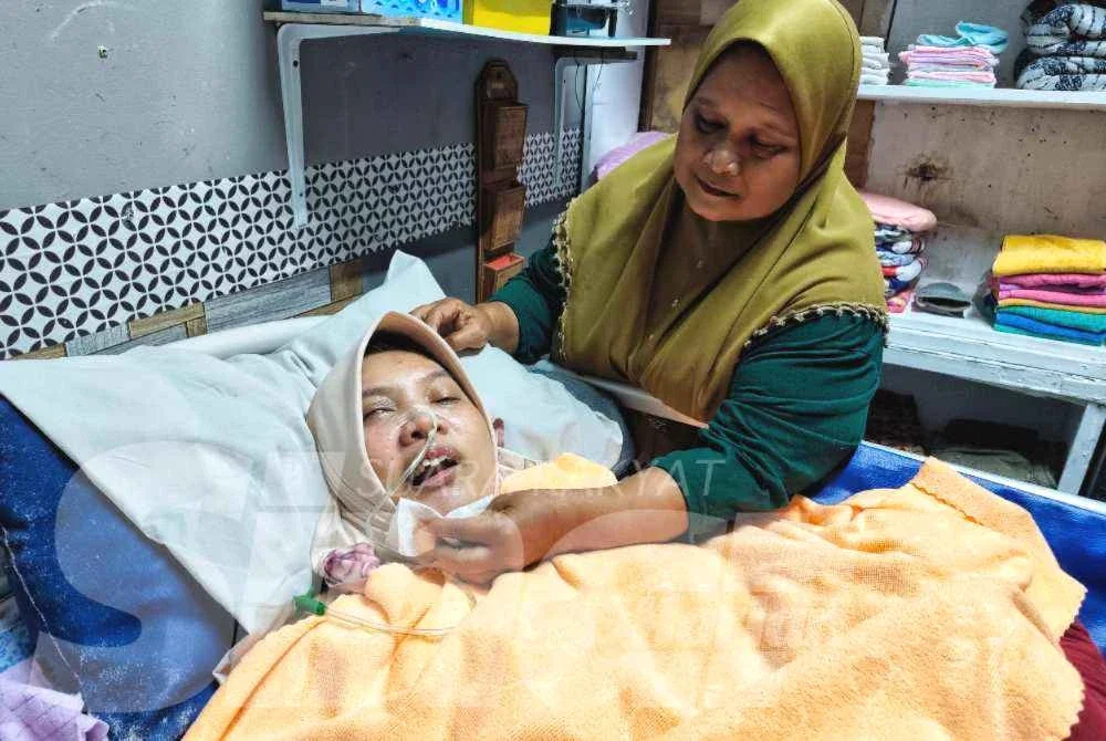 Salmiah (kanan) sentiasa mengutamakan kebajikan Nurul Syazwani yang menghadapi masalah kesihatan.