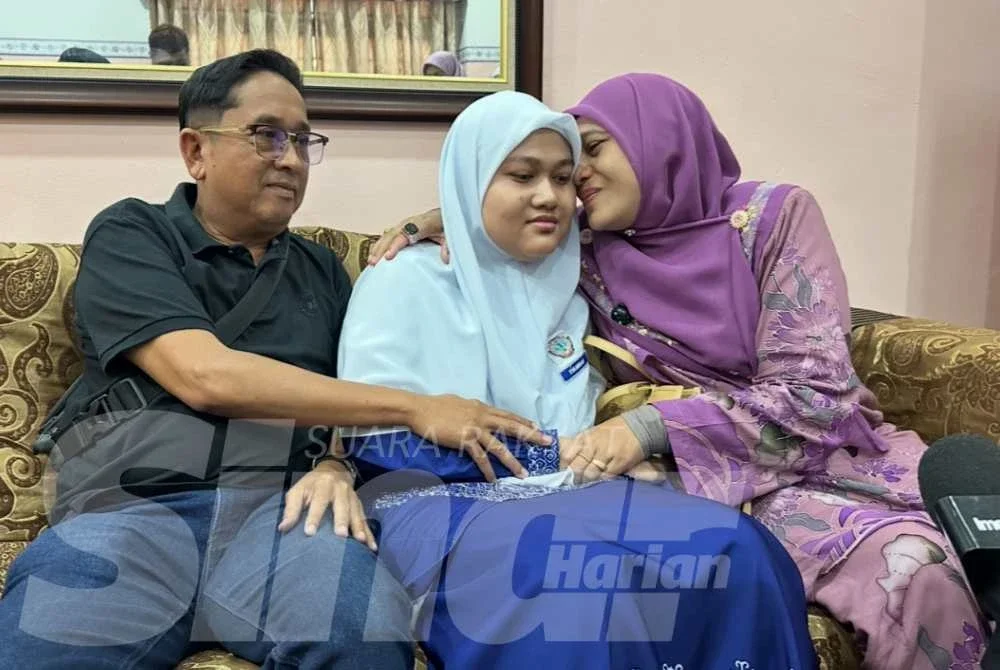 Nur Syahirah Syazwani dipeluk ibunya, Maznah (kanan) dan bapanya, Zailani (kiri). 