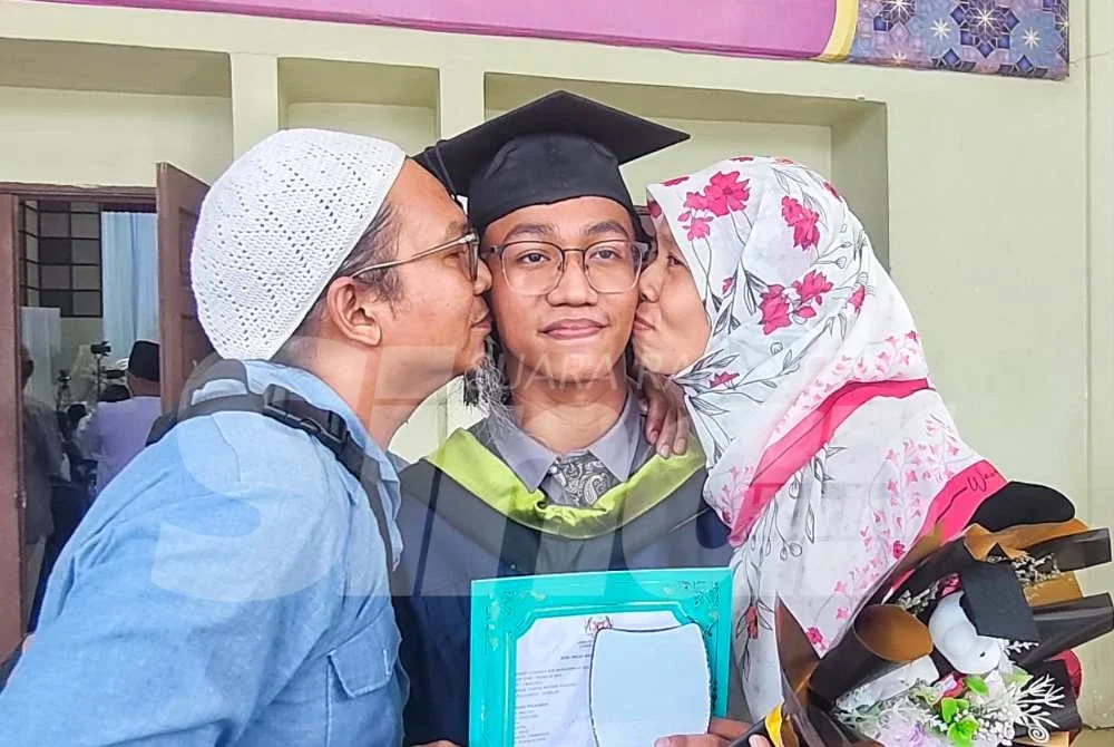 Muhammad Luqman menerima kucupan daripada ayah dan ibunya selepas selepas majlis pengumuman keputusan SPM Tahun 2025 di Dewan Mahkota MTNP pada Selasa. 