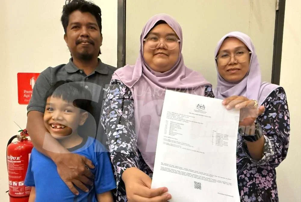 Nur Afiera Aisyah (dua dari kanan) menunjukkan keputusan SPM yang diperoleh sambil diperhatikan oleh ibu bapanya.