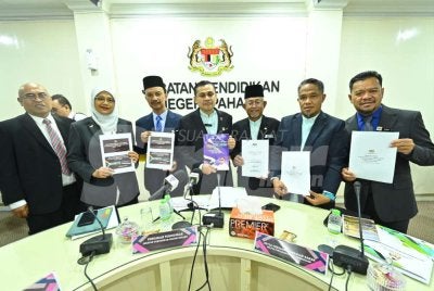 Ahmad Zamri (tengah) menunjukkan Laporan Keputusan Peperiksaan SPM 2025 bagi Negeri Pahang yang diumumkan di Jabatan Pendidikan Negeri Pahang pada Selasa.