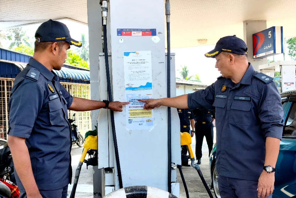 Pegawai KPDN Kelantan menunjukkan pemakluman larangan penjualan RON95 kepada kenderaan asing bermula 1 April.