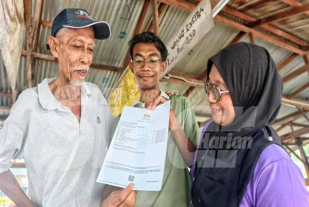 Fakhrul Iman menunjukkan keputusan peperiksaan SPM kepada kedua ibu bapanya