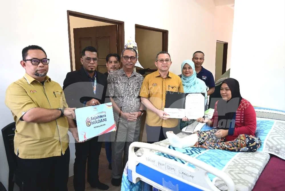 Abdul Kahar (dua dari kiri) menyerahkan kunci Rumah Kasih Ihsan kepada Zubaidah di Kampung Batu 29, Permaisuri, Setiu pada Rabu.