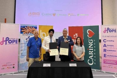 Dr Meheshinder (tengah) bersama Chong Yeow Siang, menandatangani MOU kerjasama inisiatif akses saringan awal kanser kolorektal dengan menyasarkan 10,000 individu yang layak.