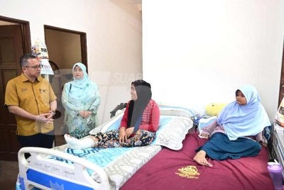 Abdul Kahar (berdiri, kiri) menziarahi penerima Rumah Kasih Ihsan kategori Bina Baharu di Kampung Batu 29, Permaisuri, Setiu pada Rabu.