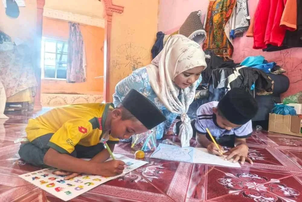 Siti Nur Jamilah bersama dua anaknya yang keciciran sekolah akibat kemiskinan semasa ditemui di Taman Naka Jaya pada Rabu.