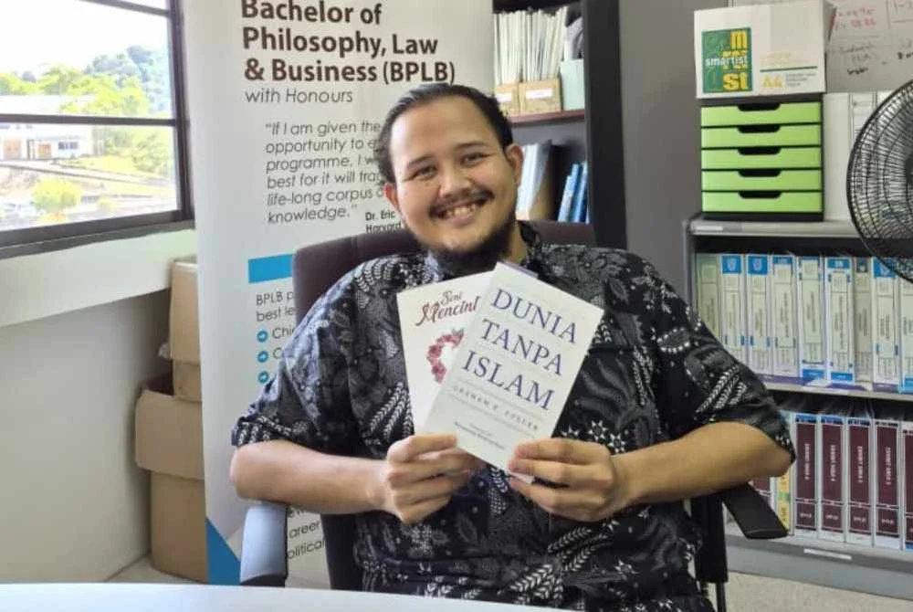 Muhammad Shuib menunjukkan buku 'Dunia Tanpa Islam' yang beliau terjemahkan daripada karya asal Graham E. Fuller.