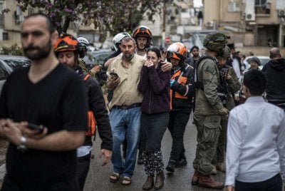 Penduduk meninggalkan sebuah bangunan pangsapuri yang terkena impak serangan susulan serangan Iran di Bnei Brak, tengah Israel. Foto AFP