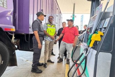 Jegan (tengah) bertanya sesuatu kepada pemandu lori ketika menghadiri menghadiri Sesi Walkabout dan Pemantauan Pelaksanaan Larangan Penjualan dan Pembelian Barang Kawalan RON95 2026 di Stesen Petronas Sungai Dua, Butterworth pada Khamis. 