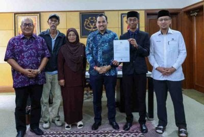 Fakhrul bersama kedua ibu bapanya bergambar bersama Asyraf Wajdi ketika mengunjungi Pengerusi Mara berkenaan.
