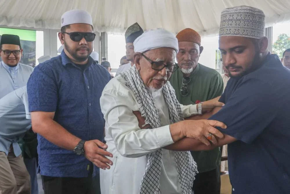 Abdul Hadi diiringi ketika memasuki bilik sidang akhbar pada Ijtimak Antarabangsa Perpaduan Ummah Kali Ke-5 dan Himpunan Alam Melayu 2026 di Kompleks Sukan Terengganu di Kuala Nerus pada Jumaat.