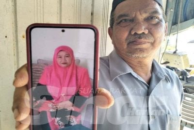 Mazelan (kanan) menunjukkan gambar Sha’adah. FOTO ADILA SHARINNI WAHID