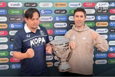 Wan Rohaimi (kiri) dan pengendali Sabah FC, Juan Torres Garrido bergambar bersama trofi Piala Cabaran.