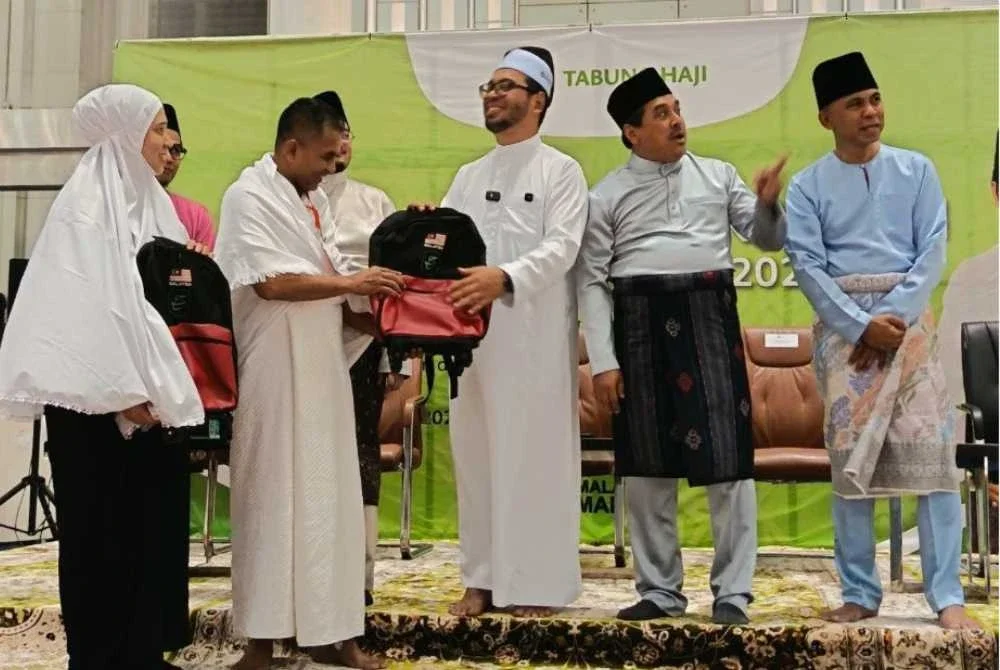Dr Zulkifli menyerahkan barang kelengkapan haji kepada jemaah.