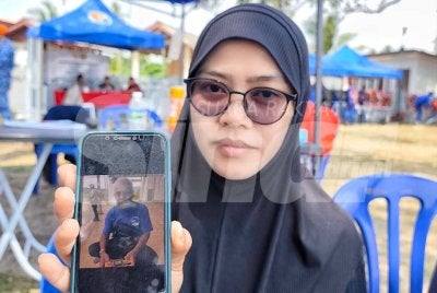 Norhidayah menunjukkan gambar ayahnya ketika ditemui di Pantai Sepat pada Sabtu.