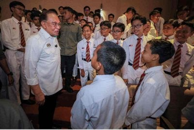Anwar (dua dari kiri) beramah mesra dengan para pelajar semasa program Temu Anwar bersama Warga MCKK di Kolej Melayu Kuala Kangsar (MCKK) hari ini. Foto: Bernama
