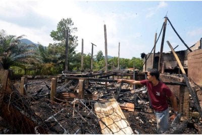 Mohd Rafain menunjukkan bahagian dipercayai kebakaran bermula yang menyebabkan rumah jirannya musnah terbakar dan menyebabkan dua beranak yang berada di dalam rumah itu cedera melecur dalam kejadian kira-kira jam 5 pagi di Kampung Oh, di sini. Foto Bernama
