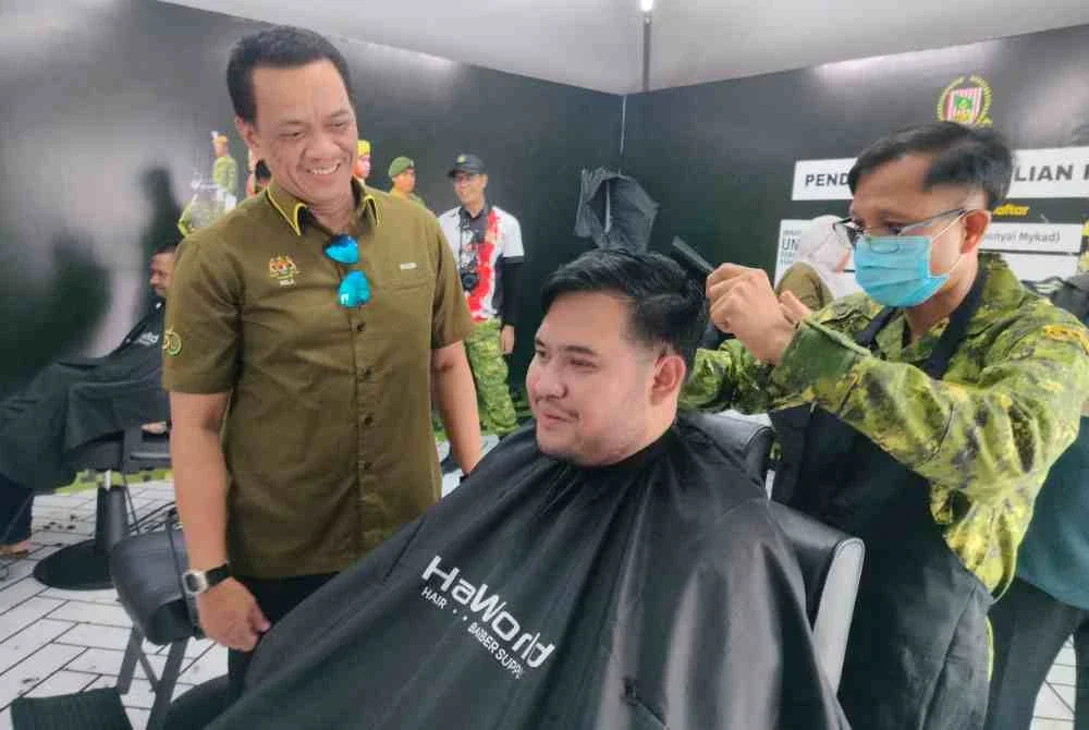 Mohamad Razib (kiri) turut meninjau kehadiran orang ramai yang mendapatkan perkhidmatan gunting rambut percuma oleh Rela Perak sempena Program Madani Rakyat.