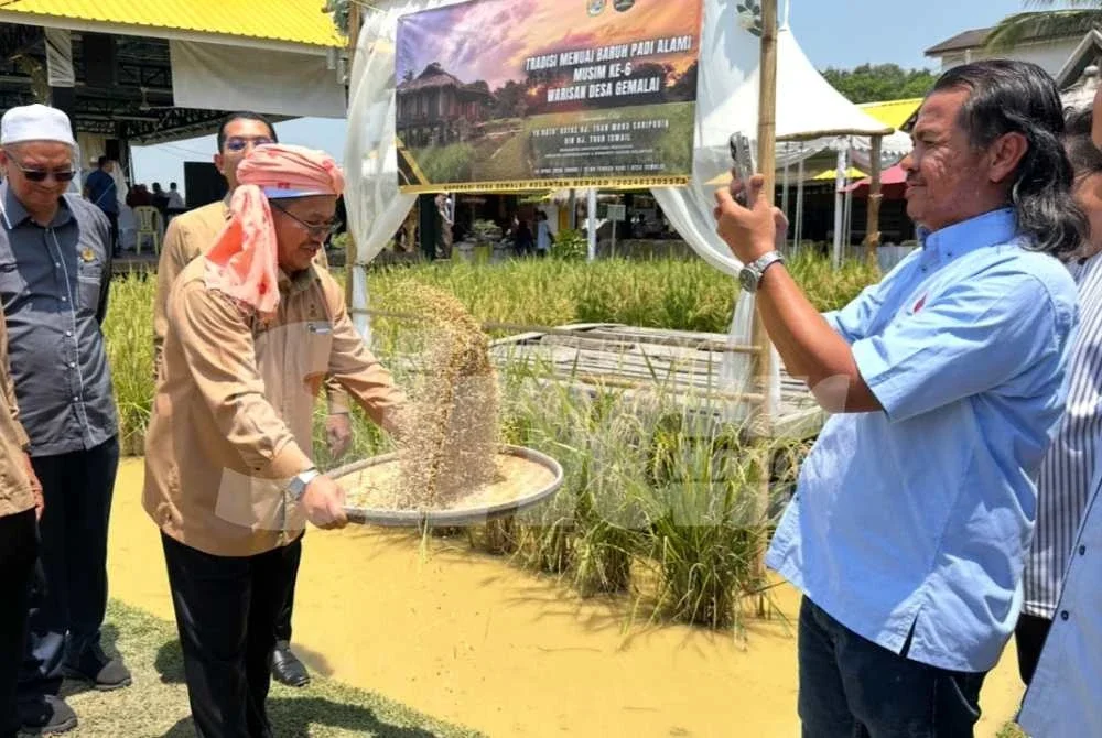 Tuan Mohd Saripudin (tengah) menampi padi sebagai gimik Penutupan Bengkel Koperasi Pertanian al-Falah di Desa Gemalai Baruh Padi Alami, Lubok Jambu pada Ahad.
