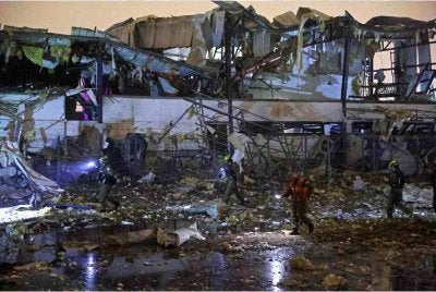 Pasukan keselamatan Israel dan petugas kecemasan memeriksa lokasi serangan peluru berpandu Iran yang menimpa kawasan kediaman di Petah Tikva. - AFP
