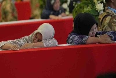 Ahli keluarga anggota pengaman Indonesia yang terkorban ketika berkhidmat bersama Pasukan Interim Pertubuhan Bangsa-Bangsa Bersatu di Lubnan (UNIFIL) menangis semasa istiadat penghormatan sebaik ketibaan jenazah mereka di Lapangan Terbang Antarabangsa Soekarno-Hatta di Tangerang, Indonesia, pada Sabtu. - Foto AP