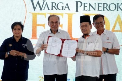 Anwar (dua dari kiri) menghadiri Program Perdana Menteri Bersama Warga Peneroka Felda di Felda Semenchu pada Ahad.