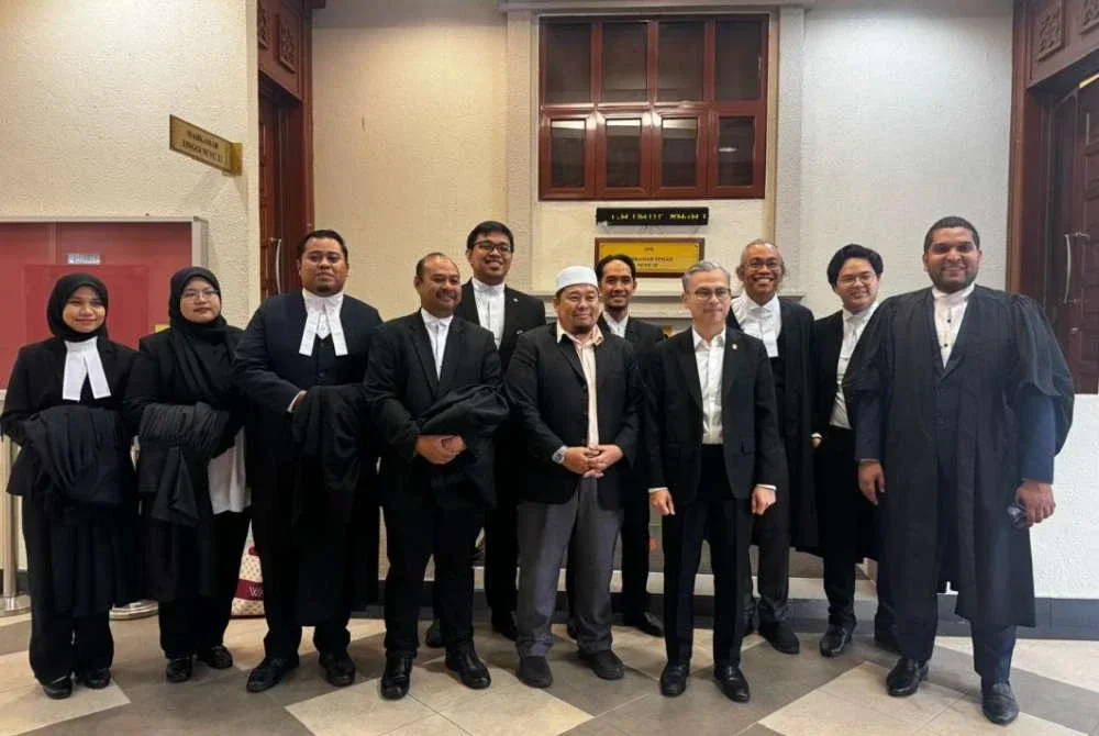 Fahmi (depan, dua dari kanan) hadir di Mahkamah Tinggi pada Isnin.