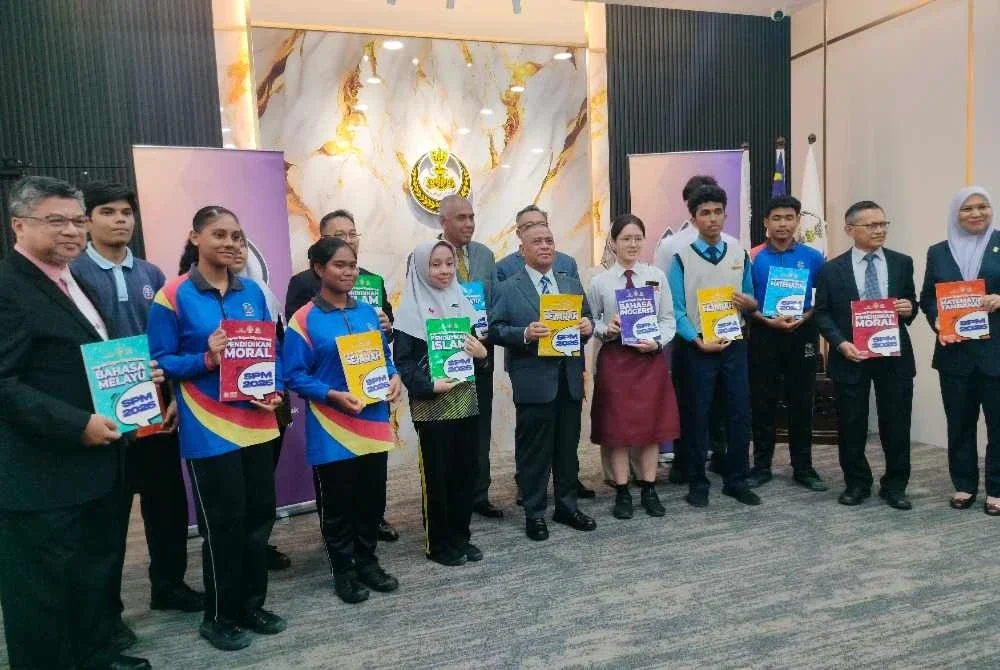 Saarani (lima dari kiri) bersama pelajar sekolah ketika menyempurnakan gimik Penyerahan Buku Rujukan Tambahan SPM Program Cikgu Saarani Tahun 2026 di Foyer Pejabat Menteri Besar Perak, Ipoh pada Isnin.