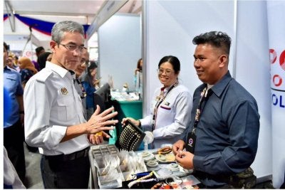 Anesee (kiri) beramah mesra bersama usahawan muda dan peserta pameran dalam lawatan rasmi beliau.