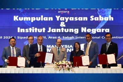 Hajiji (tengah) menyaksikan MoU yang ditandatangan Kumpulan Yayasan Sabah dan IJN di SICC, Kota Kinabalu.