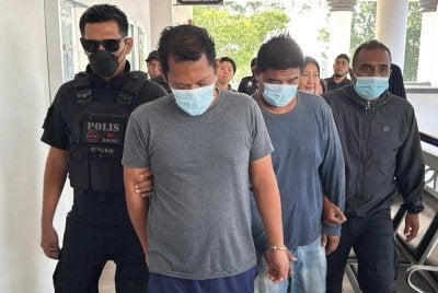 Aliff Ezry (dua dari kanan) dan Muhammad Izzuddin (dua dari kiri) diiringi anggota polis untuk didakwa di Mahkamah Alor Setar pada Isnin.