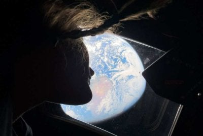 Pakar misi Artemis II, Christina Koch melihat kembali ke arah Bumi melalui tingkap kapsul Orion. - Foto AFP