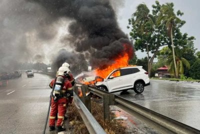 Anggota bomba menjalankan kerja pemadaman ke atas sebuah SUV jenis Chery Tiggo yang terbakar selepas terbabit dalam kemalangan libatkan lima kenderaan di Ayer Tawar pada Isnin. Foto JBPM Perak
