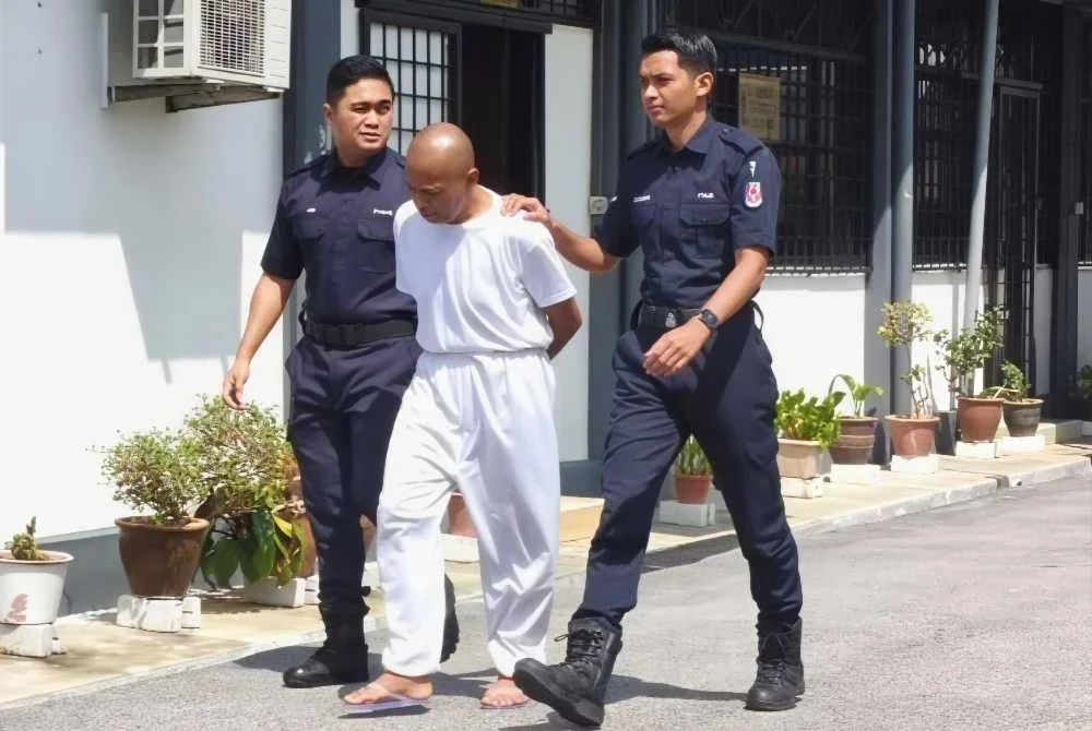 Zainizan ketika dibawa anggota polis ke Mahkamah Majistret Rembau