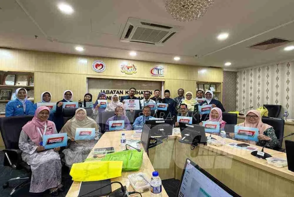 Dr Azhar dan Marhaini bergambar beramai-ramai selepas selesai sesi taklimat dan penyerahan al-Quran wakaf di JKN Melaka pada Selasa.