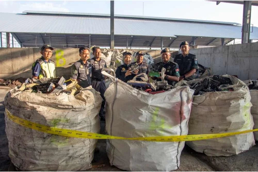 Ahmad Radzi (dua dari kanan) menunjukkan barang rampasan hasil serbuan ke atas sebuah kilang kitar semula di Bukit Ibam, Rompin pada Isnin.