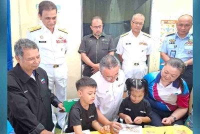 Adly (duduk, tengah) menyantuni anak-anak PPDK sempena Majlis Peluncuran Program Ikhtiar Autisme Angkatan Tentera Malaysia (IA-ATM) di PPDK Lautan Kasih di Pangkalan TLDM Lumut pada Selasa.