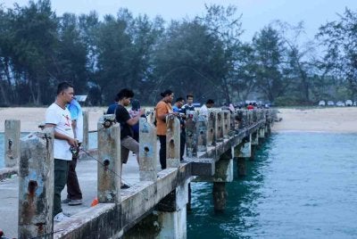 Jeti Star Cruise Kijal di Pantai Awana di sini menjadi lokasi tumpuan pemancing untuk melakukan aktiviti candat darat pada setiap petang hingga lewat malam sejak seminggu lalu. Foto Bernama 