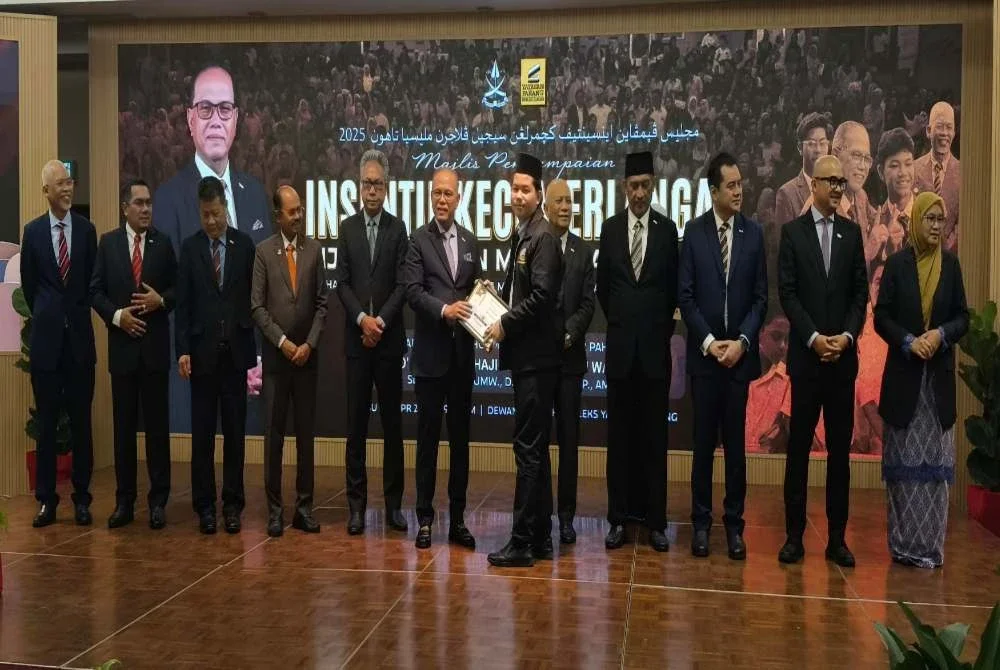 Wan Rosdy menyampaikan insentif kepada salah seorang penerima pada Majlis Penyampaian Insentif Kecemerlangan Sijil Pelajaran Malaysia (SPM) 2025 Maahad Tahfiz Negeri Pahang dan Maahad Tahfiz Turath Negeri Pahang di Kompleks Yayasan Pahang di sini pada Rabu.