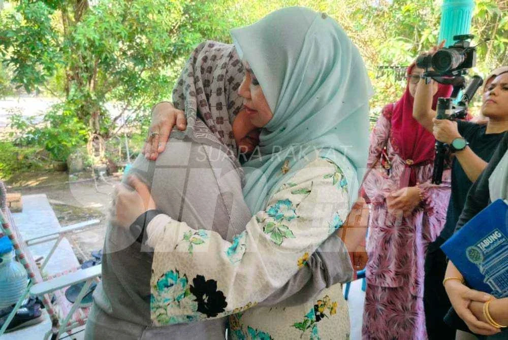Nor Nadia (kiri) ditenangkan Norliza yang hadir ke rumahnya.