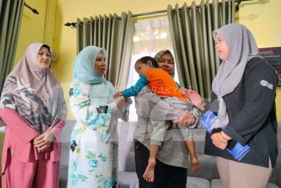 Nor Nadia (dua dari kanan) bersama anaknya, Nur Humaira menerima kunjungan Norliza (dua dari kiri) sempena Program Ziarah Kasih PTPTN di Kampung Repoh pada Rabu.
