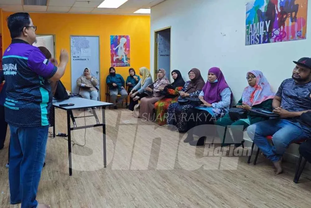 Mohd Norhisham sedang menggunakan bahasa isyarat untuk berkomunikasi walaupun boleh bertutur.