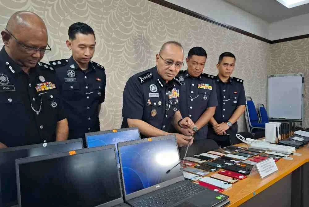Noor Hisam (tengah) menunjukkan barangan rampasan bernilai RM95,000 hasil kejayaan menumpaskan satu sindiket pusat panggilan penipuan pelaburan kripto tidak wujud yang didalangi warga China dalam serbuan di sebuah inap desa di Bagan Datuk, Selasa lalu.