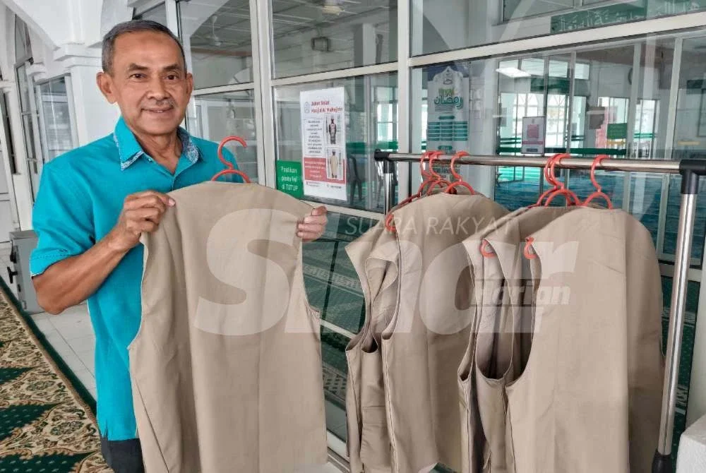 Idros menunjukkan jaket solat yang diletakkan di pintu utama masjid tersebut bagi kegunaan jemaah yang yang memakai pakaian bertulisan dan bercorak. Foto Sinar Harian.