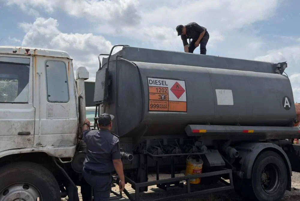Penguat kuasa KPDN Johor memeriksa lori yang diubah suai dipercayai digunakan untuk menyeleweng diesel dalam serbuan di Kawasan Perindustrian Sri Purnama, Johor Bahru.