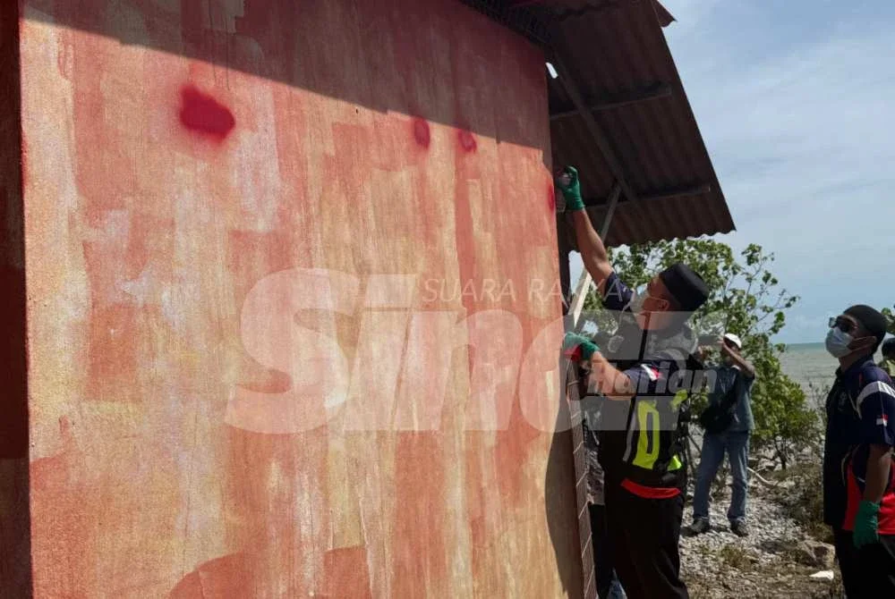 Penguat kuasa JAIM memadam kalimah ALLAH menggunakan cat pada dinding tokong berkenaan. Foto Sinar Harian 