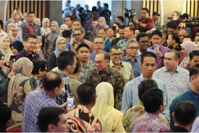 Anwar (tengah) beramah mesra bersama warga kerja Kementerian Pengangkutan pada perhimpunan bulanan kementerian itu, pada Khamis. Foto Bernama