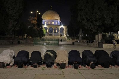 Penduduk Palestin berjemaah menunaikan solat Subuh di Haram al-Sharif pada Khamis. - Foto AFP