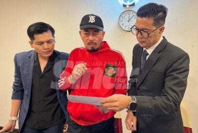 Muhammad Zaki (tengah) meneliti dokumen berkaitan kronologi kes pertikaian melibatkan dua pihak terbabit. Foto Sinar Harian/Adila Sharinni Wahid 